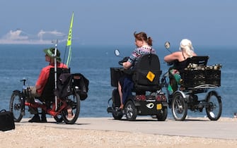 THE HAGUE, NETHERLANDS - MAY 21: People on motorized wheelchairs visit the Scheveningen beach on May 21, 2020 in The Hague, Netherlands. Dutch Prime Minister Mark Rutte said in a news conference on May 19, that restaurants, cafes, cinemas and museums can reopen with restrictions from June 1, as signs of the coronavirus (COVID-19) outbreak is coming under control.  (Photo by Yuriko Nakao/Getty Images)