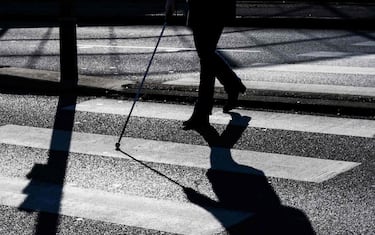 A blind person crosses a pedestrian crossing, on January 22, 2019 in Dardilly, central-eastern France. (Photo by JEFF PACHOUD / AFP)        (Photo credit should read JEFF PACHOUD/AFP via Getty Images)