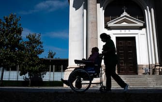 A nurse pushes an elderly resident in a wheelchair at the Tapparelli retirement home within visits of relatives on May 25, 2020 in Saluzzo near Cuneo, Piedmont, as the country eases lockdown measures taken to curb the spread of the COVID-19 pandemic, caused by the novel coronavirus. - the Tapparelli residence is home to 154 people, none of whom fell ill from the COVID-19. (Photo by MARCO BERTORELLO / AFP) (Photo by MARCO BERTORELLO/AFP via Getty Images)