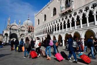 Tourists walk along the Doge's Palace (Palazzo Ducale, R) towards St Mark's Basilica (Basilica San Marco, Rear L) on November 4, 2019 in Venice. (Photo by MIGUEL MEDINA / AFP) (Photo by MIGUEL MEDINA/AFP via Getty Images)