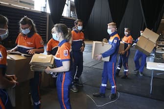 Members of the Protection Civile  prepare to deliver protective masks to the mail boxes of the population of Ajaccio on May 7, 2020, on the French Mediterranean island of Corsica, on the 52nd day of a strict lockdown across France aimed at curbing the spread of the COVID-19 pandemic, caused by the novel coronavirus. (Photo by Pascal POCHARD-CASABIANCA / AFP) (Photo by PASCAL POCHARD-CASABIANCA/AFP via Getty Images)
