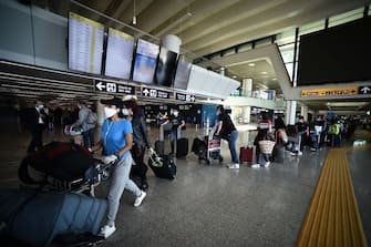 Travelers walk across a terminal at Rome's Fiumicino airport on June 3, 2020, as airports and borders reopen for tourists and residents free to travel across the country, within the COVID-19 infection, caused by the novel coronavirus. (Photo by Filippo MONTEFORTE / AFP) (Photo by FILIPPO MONTEFORTE/AFP via Getty Images)