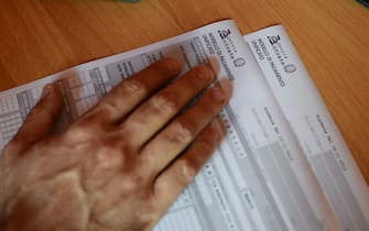 A private business consultant looks at an official tax form on October 22, 2012 in Rome. AFP PHOTO / ANDREAS SOLARO        (Photo credit should read ANDREAS SOLARO/AFP via Getty Images)