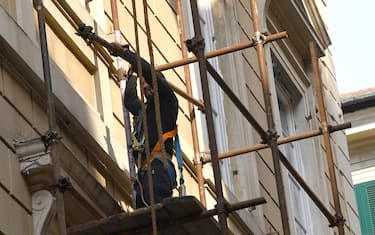 Un operaio edile su ponteggi intento a montare la ponteggiatura in un palazzo in ristrutturazione, Genova, 12 aprile 2017.
ANSA/LUCA ZENNARO