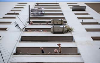 Le persone affacciate alle finestre e balconi durante il concerto 'Sotto lo stesso cielo' a Tor Bella Monaca, durante l'emergenza Covid-19, Roma, 25 aprile 2020. 
ANSA/MASSIMO PERCOSSI