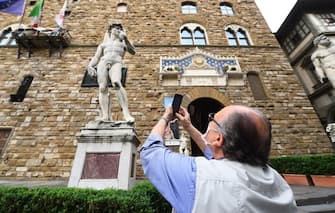 FLORENCE, ITALY - MAY 13:  A man takes a photo of a statue on the Piazza della Signoria empty of tourists  on May 13, 2020 in Florence, Italy. (Photo by Roberto Serra - Iguana Press/Getty Images)