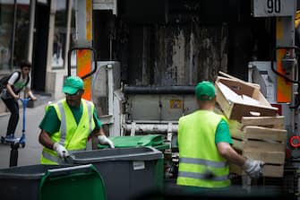 French garbage collectors empty dustbins into a refuse truck on June 10, 2016 in central Paris. 

On June 10, the day of the start of Euro 2016 in France, rubbish piled up in parts of Paris as trains were disrupted from strikes and political turmoil over labour reforms dragged on. The piles of uncollected household rubbish accumulating in parts of the capital, giving off a foul smell as the temperatures rise, was hardly the image of France that the Euro 2016 organisers want to convey. / AFP / GEOFFROY VAN DER HASSELT        (Photo credit should read GEOFFROY VAN DER HASSELT/AFP via Getty Images)