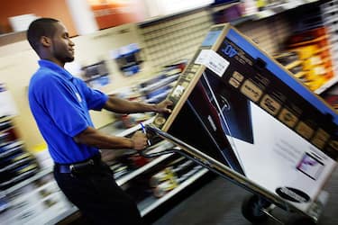 FORT LAUDERDALE, FL - JUNE 05:  James Belin, a Best Buy store customer specialist, wheels a digital ready flat screen television set to a checkout counter on June 5, 2009 in Fort Lauderdale, Florida. On June 12, America switches to the digital television signal making old analog televisions obsolete unless a converter box has been purchased. For the last 70 plus years people have watched television on analog. (Photo by Joe Raedle/Getty Images)