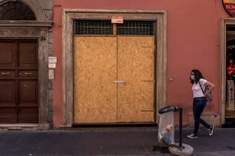 ROME, ITALY - SEPTEMBER 17: People walk past a closed shop on Via del Corso in the town centre on September 17, 2020 in Rome, Italy. With the COVID-19 pandemic and the almost total absence of foreign tourism, many shops and hotels will no longer reopen. (Photo by Stefano Montesi - Corbis/ Getty Images)