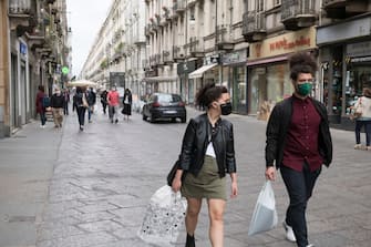 TURIN, ITALY - MAY 29: People wearing a protective mask walking through the streets of the city center on May 29, 2020 in Turin, Italy. The Piedmont Region in complete autonomy declared that from today 29 May it is mandatory to use the protective mask even outdoors to prevent further infections from Coronavirus (Covid 19). Many Italian businesses have been allowed to reopen, after more than two months of a nationwide lockdown meant to curb the spread of Covid-19. (Photo by Stefano Guidi/Getty Images)