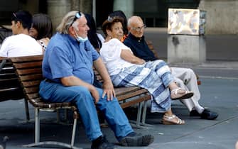 Un gruppo di signori anziani si riposa all'ombra in questa giornata di caldo intenso in Piazza Castello a Milano, 31 luglio 2020.ANSA/Mourad Balti Touati

