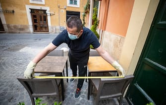 Un dipendente di un ristorante del centro storico di Roma prende le misure per il distanziamento di sicurezza in vista dell'apertura, durante l'emergenza Covid-19, Roma, 17 maggio 2020.
ANSA/MASSIMO PERCOSSI