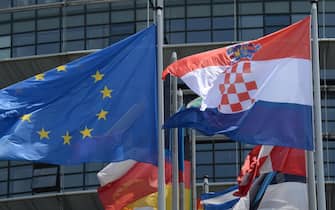 epa03771264 The Croatian flag (R) flies next to European flags outside the European Parliament in Strasbourg, France, 02 July 2013. Following the successful ratification of its European Union Accession Treaty by the national parliaments of the 27 Member States, the Republic of Croatia has joined the EU as the 28th member on 01 July 2013.  EPA/PATRICK SEEGER