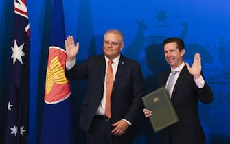 epa08821130 Australian Trade Minister Simon Birmingham (R) and Australian Prime Minister Scott Morrison (L) react after signing the Regional Comprehensive Economic Partnership (RCEP) during a virtual signing ceremony at Parliament House in Canberra, Australia, 15 November 2020.  EPA/LUKAS COCH NAUSTRALIA AND NEW ZEALAND OUT