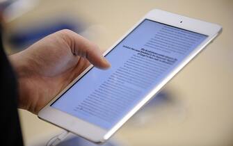 A man reads on a new iPad mini during the opening of a new Apple store on November 15, 2012 in Saint-Herblain, western France.    AFP PHOTO / JEAN-SEBASTIEN EVRARD        (Photo credit should read JEAN-SEBASTIEN EVRARD/AFP via Getty Images)