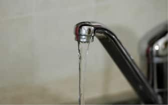 Acqua scorre da un rubinetto in una casa