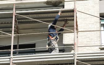 Un operaio edile sui ponteggi di un palazzo in ristrutturazione, in una immagine del 18 aprile 2017.
ANSA/LUCA ZENNARO