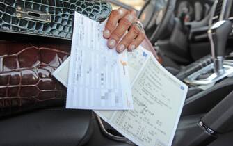 una donna tiene in mano i documenti della macchina
