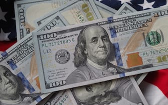 UKRAINE - 2021/01/18: In this photo illustration, US 100 dollar bills seen on an American flag. (Photo Illustration by Igor Golovniov/SOPA Images/LightRocket via Getty Images)