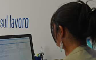 Una donna al lavoro in ufficio mentre controlla la posta elettronica al computer