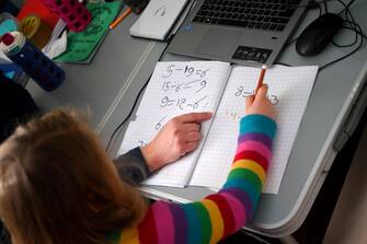 NEWCASTLE-UNDER-LYME, ENGLAND - JANUARY 25:  Five-year-old Lois Copley-Jones, who is the photographer's daughter, does her Maths studies in her bedroom on January 25, 2021 in Newcastle-under-Lyme, England. Under current government policy, schools in England wouldn't open before the February half-term break at the earliest, but the Prime Minister has declined to commit to reopening them before Easter. (Photo by Gareth Copley/Getty Images)