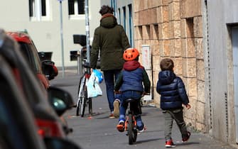 Bambini passeggiata con genitori nei parchi nonostante i divieti di accedervi a piedi  in bicicletta o monopattino,Milano 01 aprile 2020 , ANSA / PAOLO SALMOIRAGO
