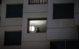 Australian resident Sara Medici, partner of the photographer, stands in the window of her hotel room during mandatory quarantine as a result of COVID-19 restrictions after arriving from Italy, in Sydney on September 25, 2020, in Australia. Sara Medici spent two weeks in mandatory hotel quarantine after her return from Italy to Australia. All international arrivals into Australia must go into mandatory 14-day hotel quarantine as part of Australia's strict border controls due to the ongoing COVID-19 pandemic.   (Photo by David Gray/Getty Images)