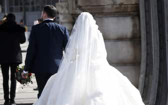 PARIS, FRANCE - MARCH 15: A couple in wedding dress and gown walk along a road amid the coronavirus outbreak on March 15, 2020 in Paris, France. Similar scenes of shuttered cafes, quiet streets and empty stores played out across the French capital after prime minister Edouard Philippe announced restrictions on French public life unprecedented in living memory. (Photo by Li Yang/China News Service via Getty Images)