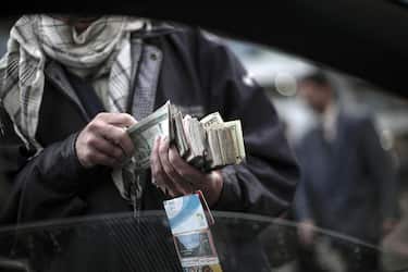 An Afghan street seller offers the local currency called 'afgani' in exchange for US dollars and few pre-paid mobile phone cards, in  Kabul, on April 10, 2010. The United States rolled out the red carpet for Afghan President Hamid Karzai as he started a four-day visit, hoping to patch up public spats that cast a shadow over joint war efforts. AFP PHOTO/Mauricio LIMA (Photo credit should read MAURICIO LIMA/AFP via Getty Images)