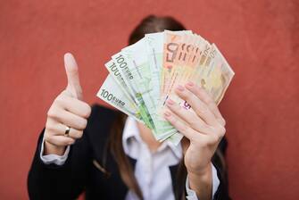 1226933560 Woman holding bunch of euros as a result of financial , government aid or loan approved