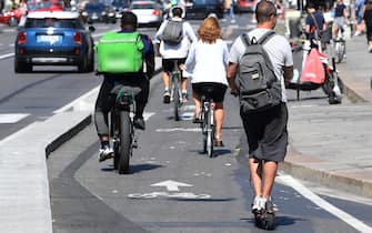 Una persona su un monopattino elettrico in una delle ve del centro, Milano, 6 settembre 2021. Obbligo di assicurazione per responsabilità civile, limitazione della conduzione alle sole persone che abbiano compiuto 18 anni di età, con conseguente divieto per i minori, ed estensione a tutti i conducenti dell'obbligo di indossare il casco protettivo, oggi previsto solo per gli under 18. Sono i contenuti della proposta di legge al Parlamento per modificare le disposizioni vigenti sui monopattini elettrici approvata dalla Regione LombardiaANSA/DANIEL DAL ZENNARO