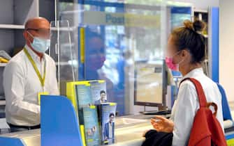 una ragazza allo sportelli delle poste