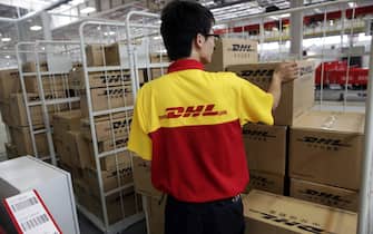 epa03304328 Employees move boxes during the test operation of the newly opened DHL North Asia Hub in Shanghai, China, 12 July 2012. DHL opened its largest express hub in Asia, the 175 million US dollars DHL Express North Asia Hub at the Shanghai Pudong International Airport.  EPA/Qilai Shen