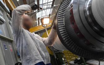 Un operaio al lavoro su una turbina