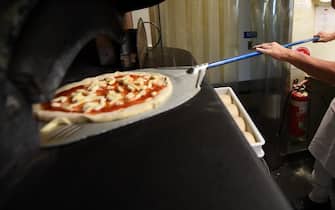 epaselect epa09535394 Chef Santosh cooks a pizza at a restaurant a day ahead of their reopening in Elsternwick, Melbourne, Victoria, Australia, 21 October 2021. A further 2,232 local COVID-19 cases and 12 deaths have been reported in Victoria as Melbourne prepares for the end of its sixth lockdown.  EPA/JAMES ROSS  AUSTRALIA AND NEW ZEALAND OUT