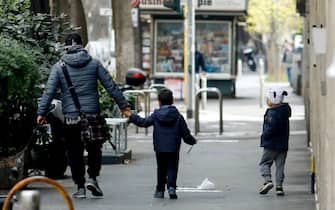 Genitori a passeggio con i figli a Milano, 1 aprile 2020. ANSA/Mourad Balti Touati
