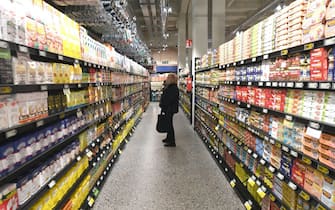 Una donna tra gli scaffali di un supermercato mentre fa la spesa