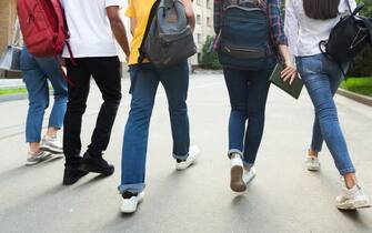 1166780821 Unrecognizable teenage students in high school campus walking at break, crop