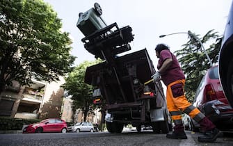 Operatori dell'Ama a lavoro per la pulizia delle strade, servizio portata a porta e svuotamento dei contenitori dei rifiuti all'Eur, 12 maggio 2017. ANSA/ANGELO CARCONI