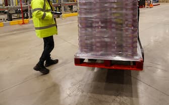 Employees move a pallet of Quality Street chocolates, manufactured by Nestle SA, at a distribution warehouse operated by GXO Logistics Inc. near Derby, U.K., on Friday, Dec. 10, 2021. British logistics companies are taking steps to boost training, recruitment and pay, "yet there remains concern that some supply chain disruption will continue in 2022 until these crucial roles are filled across the industry," a report by trade organization Logistics UK warned. Photographer: Chris Ratcliffe/Bloomberg via Getty Images