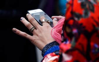 Woman using smartphone at Paris Fashion Week 2016