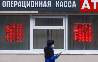 MOSCOW, RUSSIA - FEBRUARY 22, 2022: A man walks past digital boards displaying the current rates outside a currency exchange office. The US dollar has exceeded a January 27 high of 79 against the Russian rouble at the Moscow Exchange. Sergei Fadeichev/TASS (Photo by Sergei Fadeichev\TASS via Getty Images)