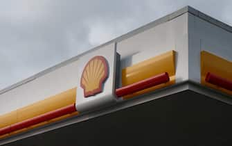 The company logo sits above the forecourt of a gas station operated by Royal Dutch Shell Plc in Alkmaar, Netherlands, on Wednesday, Jan. 23, 2014. Europe's biggest oil company, in its first profit warning since 2004, said adjusted earnings excluding one-time items and inventory changes were about $2.9 billion in the fourth quarter. Photographer: Jasper Juinen/Bloomberg