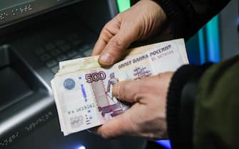 MOSCOW, RUSSIA - FEBRUARY 28, 2022: This image shows a person holding cash withdrawn from an ATM machine at a Sberbank branch. On February 24, the United States announced it was imposing sanctions on major Russian banks, including Sberbank and VTB in response to the special military operation in Ukraine. According to the Sberbank press office, the bank continues to operate normally, with all transactions associated with mortgages and foreign securities available. Anton Novoderezhkin/TASS/Sipa USA