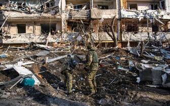 Police experts learn a funnel in the place of explosion  of a wing missile near Residential apartment building in residential district of Kyiv after it was hit by shelling early morning as Russia's invasion of Ukraine continues, in Kyiv, Ukraine, March 15, 2022 (Photo by Maxym Marusenko/NurPhoto via Getty Images)