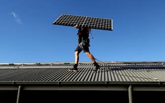 A Solarpro employee holds a LG Electronics Inc. NeON R 370W solar panel ahead of installation on the rooftop of a residential property in Sydney, Australia, on Monday, May 17, 2021. Australia is the global leader in generating electricity from the sun. Some 27% of buildings had a solar system on their roof at the end of 2020, the highest proportion in the world, according to figures from BNEF. Photographer: Brendon Thorne/Bloomberg via Getty Images