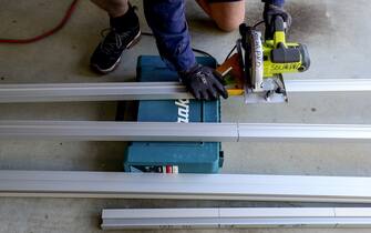 A Solarpro employee cuts railings for LG Electronics Inc. NeON R 370W solar panels ahead of installation to the rooftop of a residential property in Sydney, Australia, on Monday, May 17, 2021. Australia is the global leader in generating electricity from the sun. Some 27% of buildings had a solar system on their roof at the end of 2020, the highest proportion in the world, according to figures from BNEF. Photographer: Brendon Thorne/Bloomberg via Getty Images