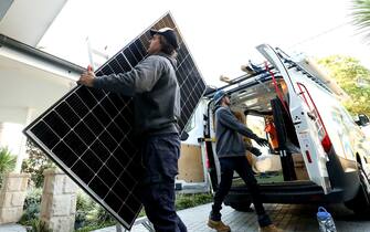 A Solarpro employee unloads a LG Electronics Inc. NeON R 370W solar panel from a truck ahead of installation to the rooftop of a residential property in Sydney, Australia, on Monday, May 17, 2021. Australia is the global leader in generating electricity from the sun. Some 27% of buildings had a solar system on their roof at the end of 2020, the highest proportion in the world, according to figures from BNEF. Photographer: Brendon Thorne/Bloomberg via Getty Images