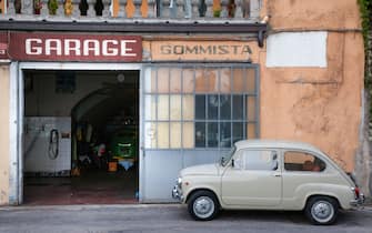 Old Italian Fiat parked outside a garage in Italy