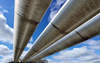 Three pipeline reflecting blue sky.